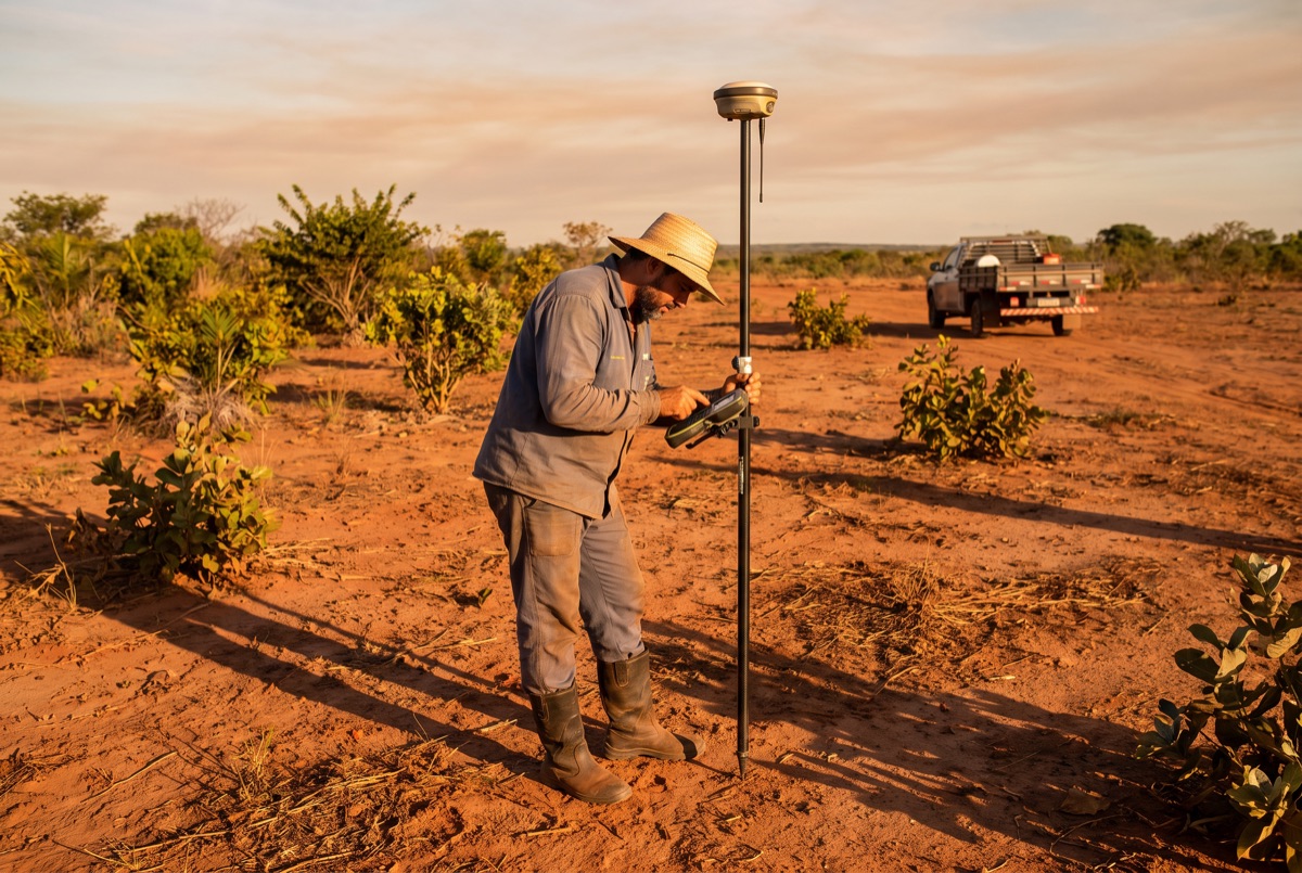Profissional operando receptor GNSS RTK em campo aberto